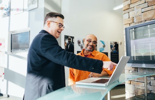 Technician and a businessman discussion with a laptop